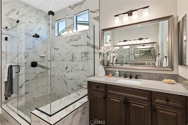 bathroom with an enclosed shower, vanity, and decorative backsplash