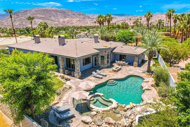 view of pool with a patio area, a mountain view, and an in ground hot tub