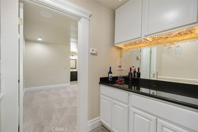 bar with light colored carpet and white cabinets