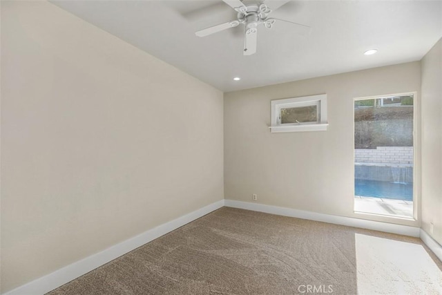 spare room with ceiling fan and carpet