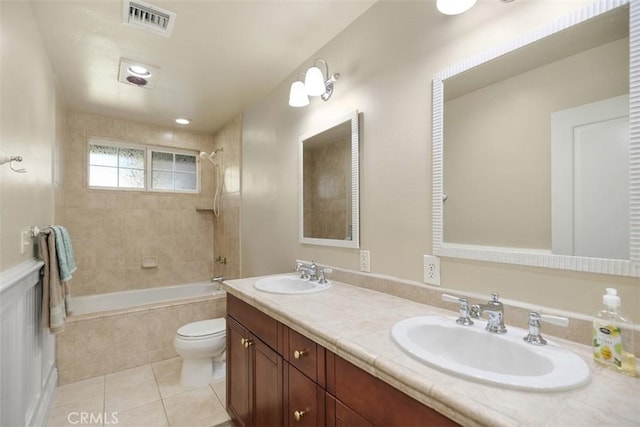 full bathroom with tile patterned flooring, vanity, tiled shower / bath combo, and toilet