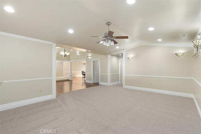 carpeted spare room with ornamental molding, lofted ceiling, and ceiling fan with notable chandelier