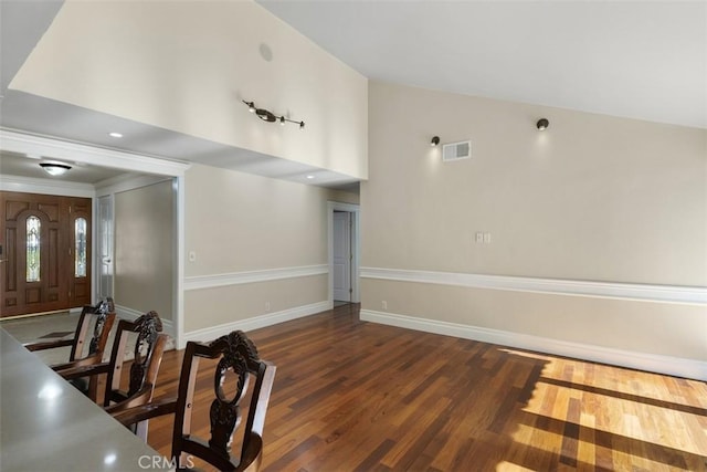 interior space with dark wood-type flooring and high vaulted ceiling