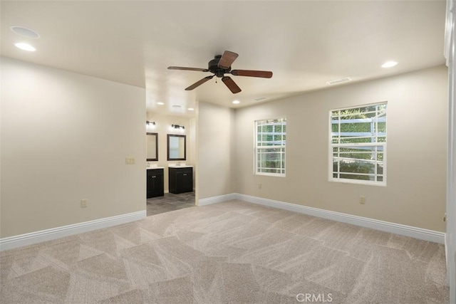 carpeted spare room featuring ceiling fan