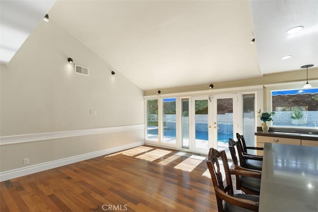 unfurnished living room featuring french doors, high vaulted ceiling, and hardwood / wood-style flooring