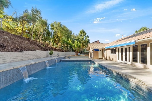 view of pool with pool water feature and french doors