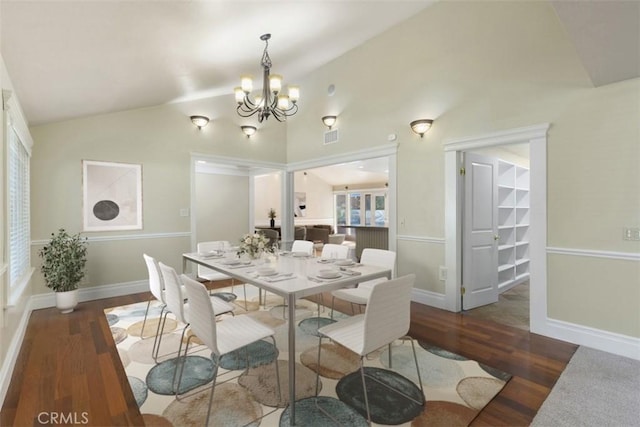 dining room with vaulted ceiling, a notable chandelier, and dark hardwood / wood-style flooring