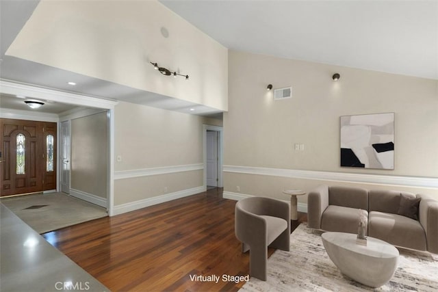 living room with dark wood-type flooring and high vaulted ceiling