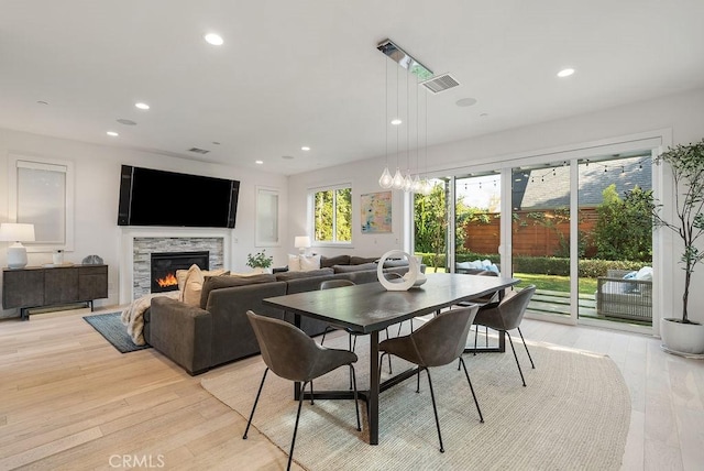 dining area with a fireplace and light wood-type flooring