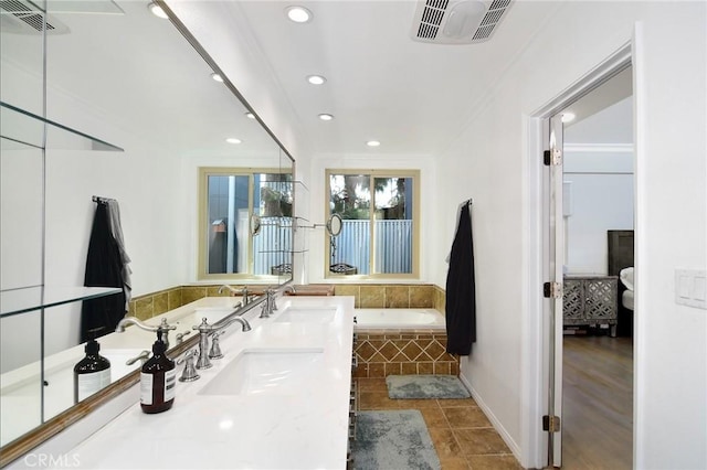 bathroom featuring tiled bath and vanity