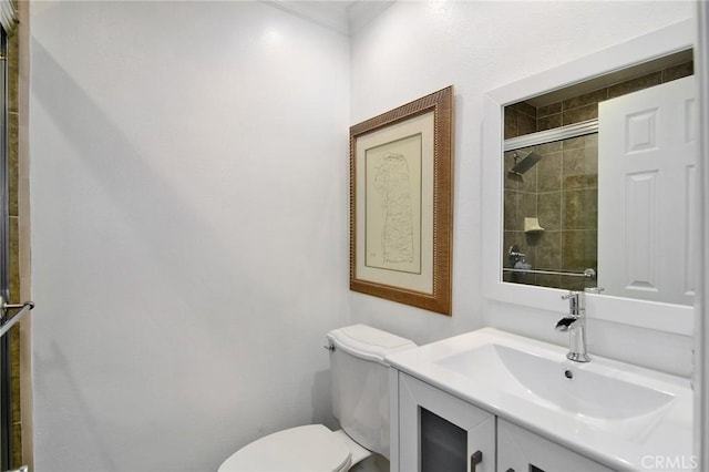 bathroom featuring toilet, an enclosed shower, and vanity