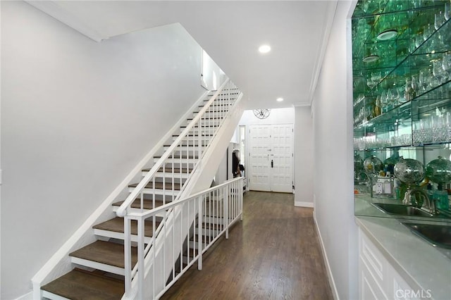 stairs featuring crown molding and wood-type flooring