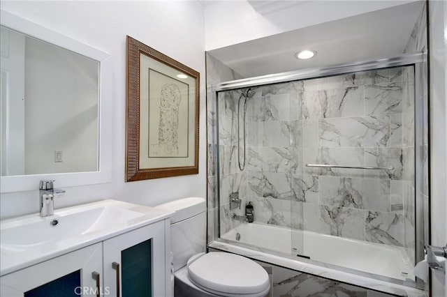 full bathroom featuring toilet, enclosed tub / shower combo, and vanity