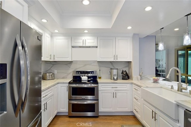 kitchen featuring tasteful backsplash, sink, white cabinetry, hanging light fixtures, and stainless steel appliances