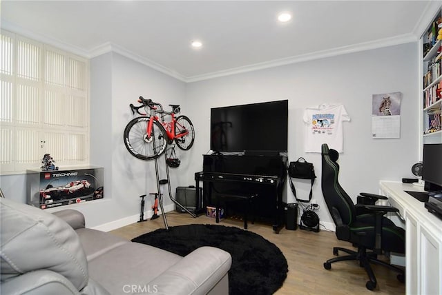 home office with light wood-type flooring and ornamental molding