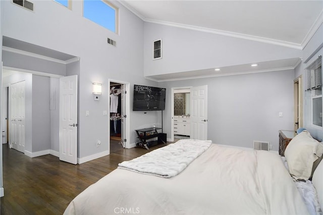 bedroom featuring ensuite bath, crown molding, a walk in closet, a closet, and dark hardwood / wood-style flooring