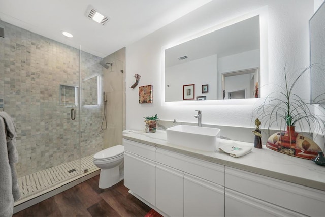 bathroom with vanity, toilet, hardwood / wood-style floors, and an enclosed shower