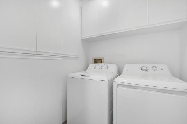 laundry area featuring cabinets and washer and clothes dryer