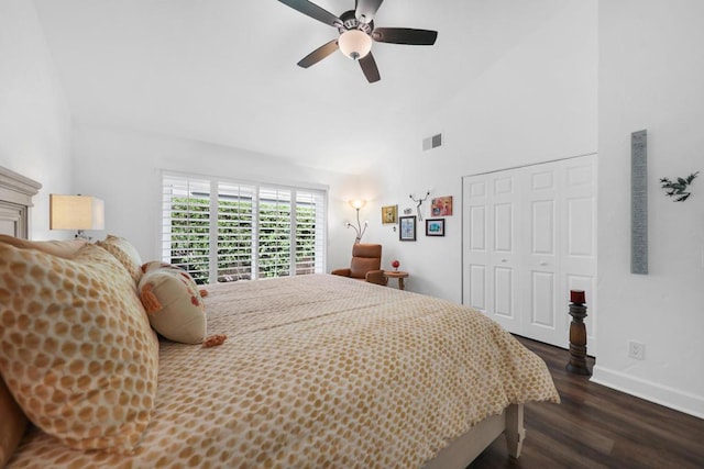 bedroom with a closet, dark hardwood / wood-style floors, high vaulted ceiling, and ceiling fan