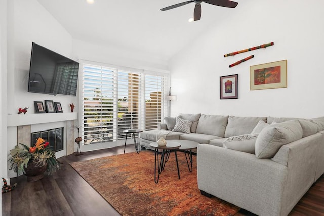 living room with ceiling fan, dark wood-type flooring, and lofted ceiling