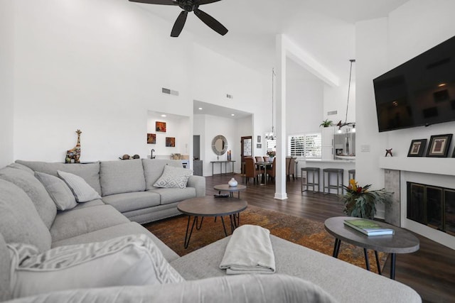 living room featuring ceiling fan, high vaulted ceiling, and dark hardwood / wood-style flooring