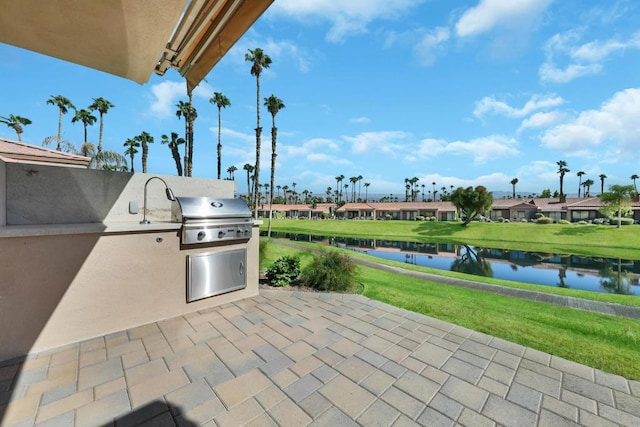 view of patio / terrace with area for grilling, a water view, and grilling area