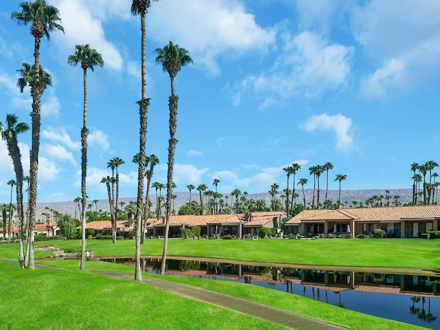 view of home's community featuring a lawn and a water view