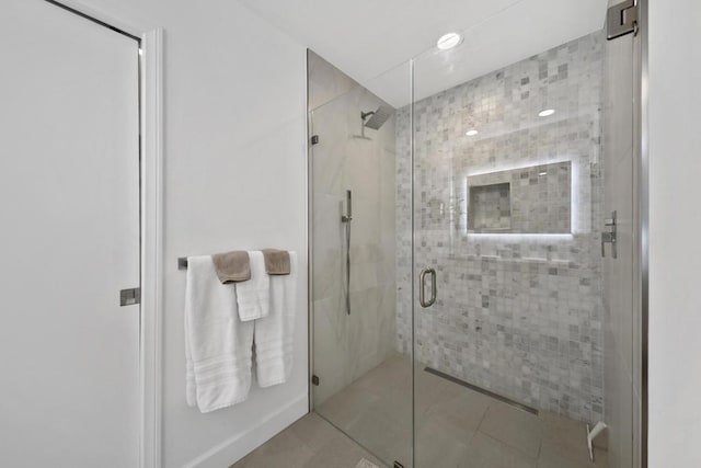 bathroom featuring a shower with door and tile patterned flooring