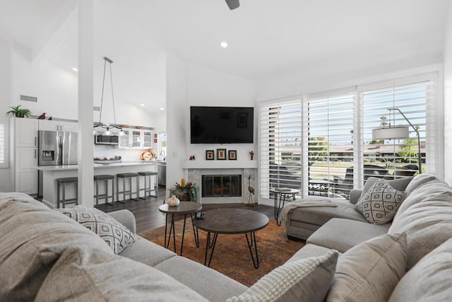 living room with ceiling fan, high vaulted ceiling, and dark hardwood / wood-style flooring