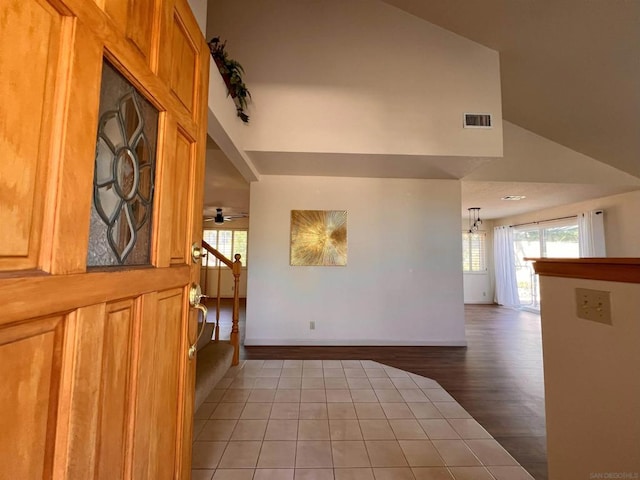 empty room featuring ceiling fan, high vaulted ceiling, and light hardwood / wood-style flooring