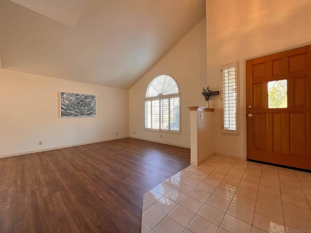 tiled foyer featuring high vaulted ceiling