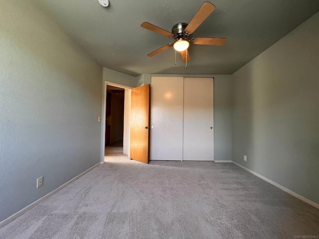 unfurnished bedroom with ceiling fan, a closet, and light carpet