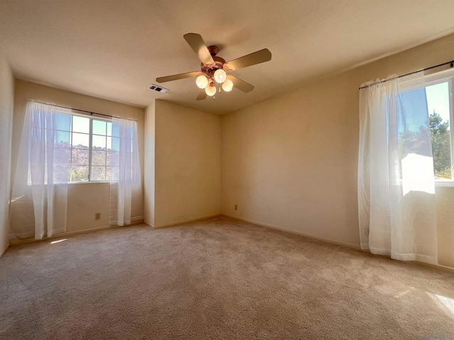 carpeted spare room with ceiling fan