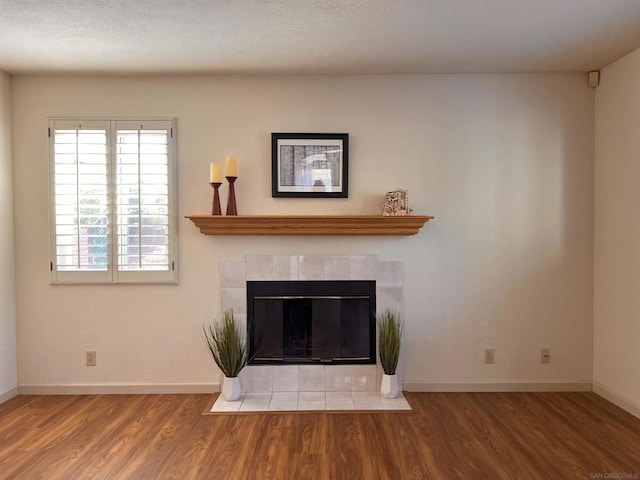 room details featuring hardwood / wood-style flooring and a tile fireplace