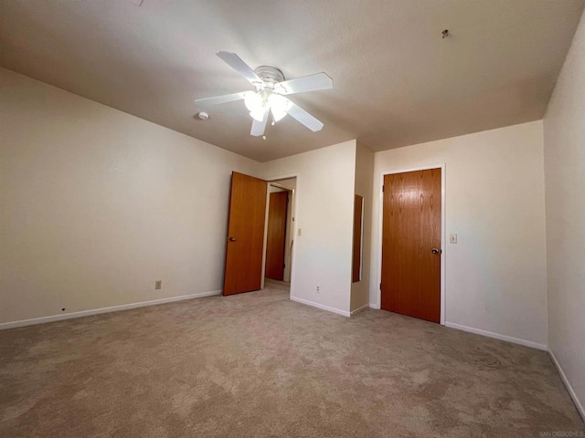 carpeted spare room with ceiling fan