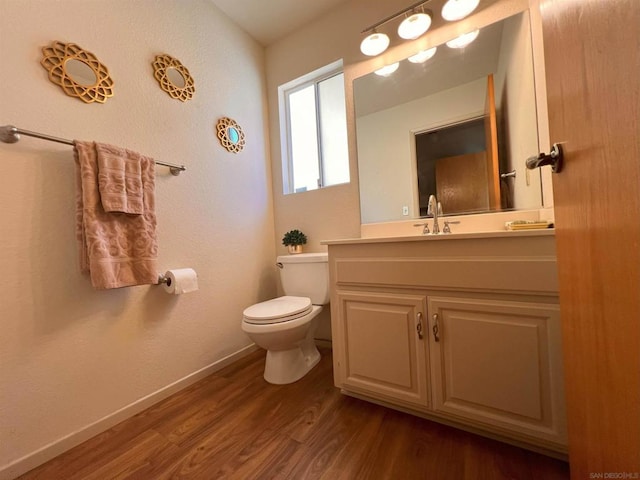 bathroom featuring toilet, hardwood / wood-style floors, and vanity