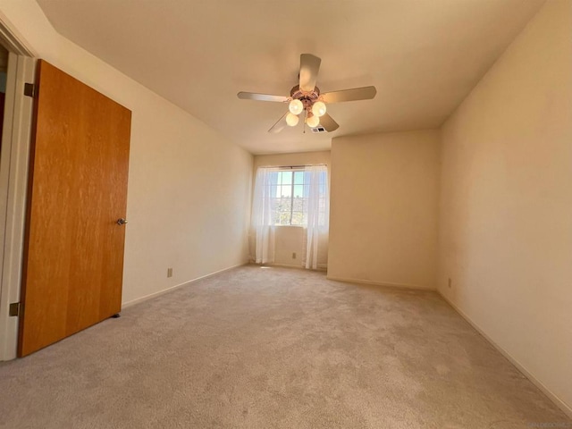 unfurnished room with ceiling fan and light colored carpet