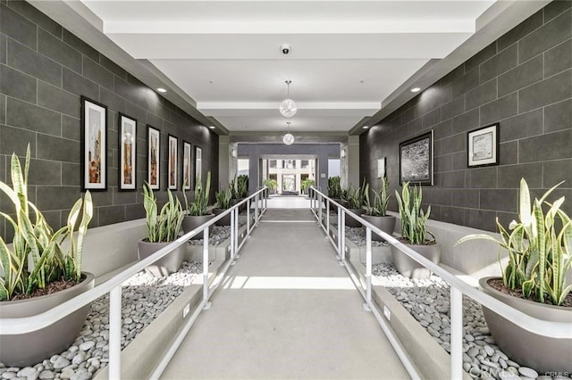 corridor featuring concrete floors and tile walls