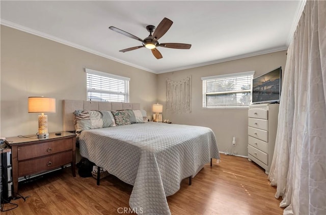 bedroom featuring ceiling fan, multiple windows, and hardwood / wood-style floors