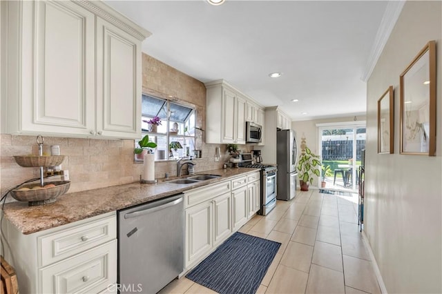 kitchen with light stone counters, sink, white cabinetry, and stainless steel appliances