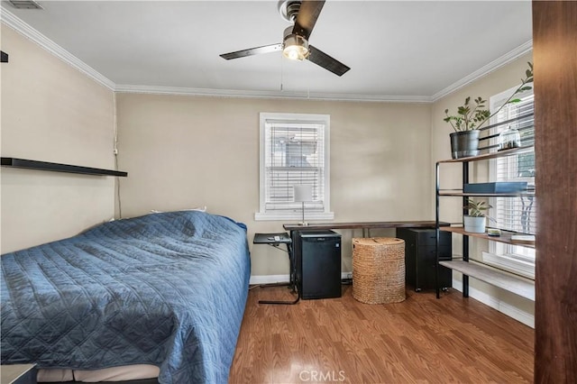 bedroom featuring ceiling fan, ornamental molding, and hardwood / wood-style floors