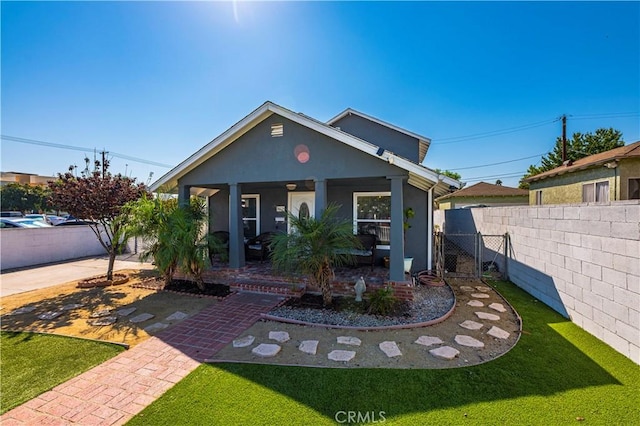 view of front of house with covered porch and a front lawn