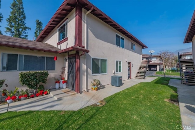 exterior space featuring a yard, a patio, and central air condition unit