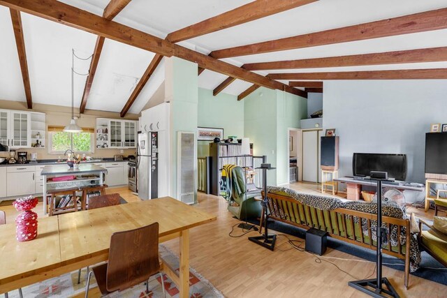 interior space with high vaulted ceiling, light hardwood / wood-style flooring, and beam ceiling