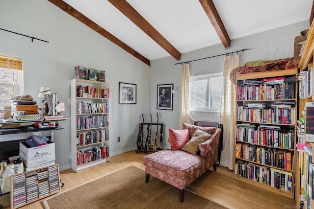 sitting room featuring vaulted ceiling with beams and light hardwood / wood-style floors