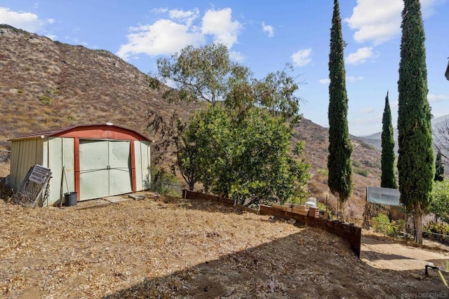 view of yard with a storage unit and a mountain view