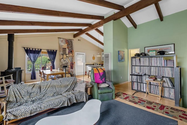 living room featuring a wood stove, hardwood / wood-style floors, and lofted ceiling with beams