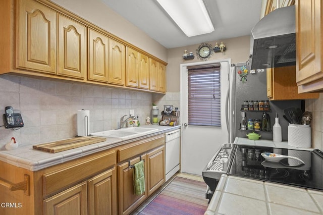 kitchen with tile counters, stove, sink, and white dishwasher