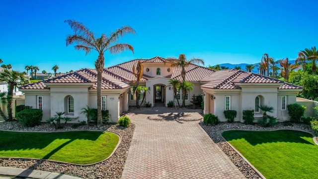 mediterranean / spanish home featuring a front yard