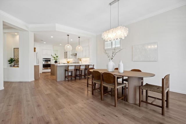 dining room featuring a chandelier, crown molding, and light hardwood / wood-style flooring